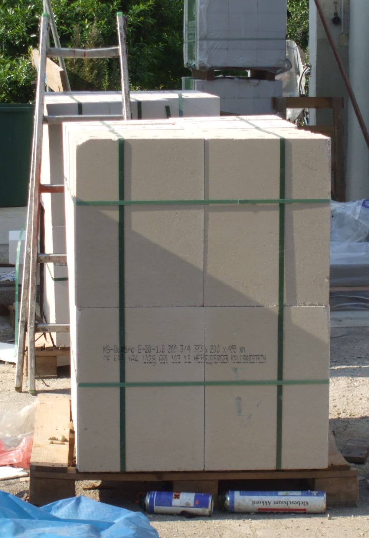 Industrial masonry blocks bundled on a pallet with green PET plastic straps